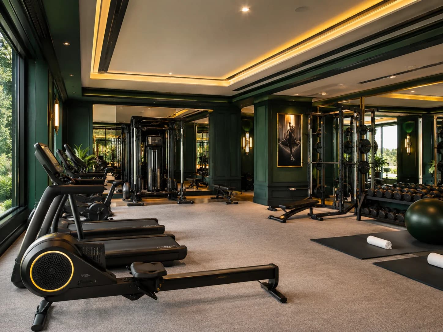 The Al Rayyan garden room as delivered: deep green panelling, mirrored bays, and a full training floor facing the garden.